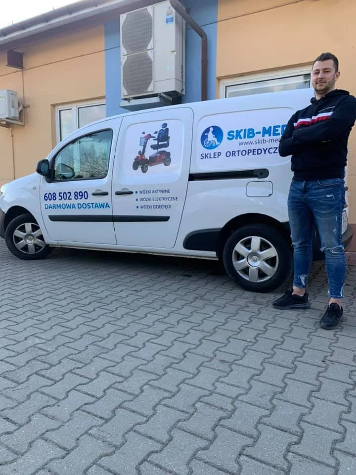 Piotr Skiba fizjoterapeuta przed samochodem firmowym SKIB-MED sklep medyczny ortopedyczny z darmową dostawą sprzętu rehabilitacyjnego